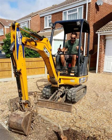 using a mini digger to clear a garden|digging a mini garden.